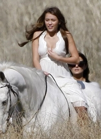 Miley Ray Cyrus in white on white horse